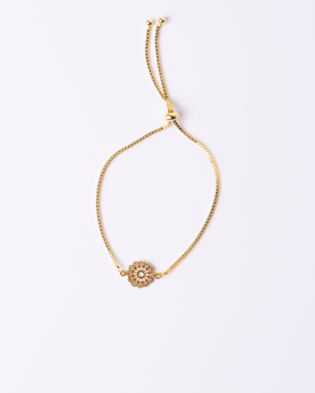 Adjustable Gold bracelet with a decorative clasp and small daisy charm.